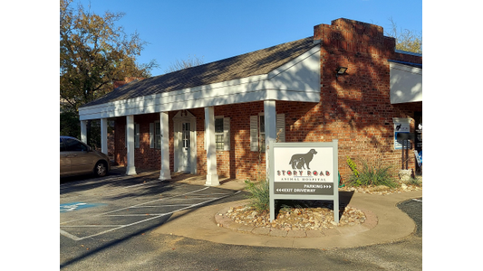 Brick building with white columns and a sign reading "Story Road Animal Hospital" in front. A car is parked nearby.