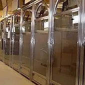 A row of Deluxe Suite animal kennels with arched tops, inside a well-lit facility.