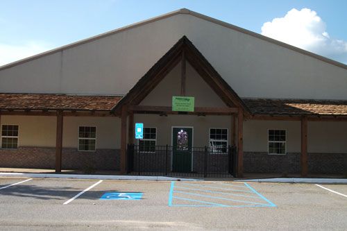 Happy Dogs Play and Stay exterior with a green sign and accessible parking