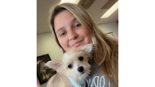 Victoria - Groomer holding a small dog