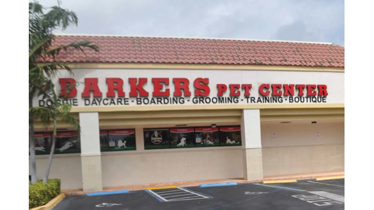 Storefront of Barkers Pet Center with signage advertising doggie daycare, boarding, grooming, training, and boutique services.