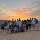 Students on a hilltop at sunset