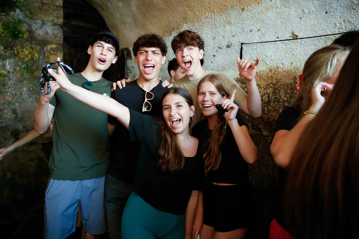 Muss students together inside a stone water tunnel in Israel