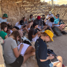 Students sitting together outdoors on a rocky site
