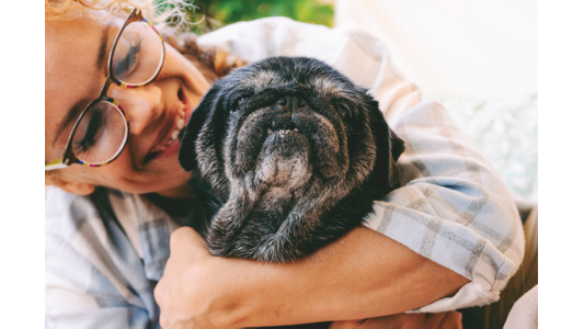 Woman hugging old dog.