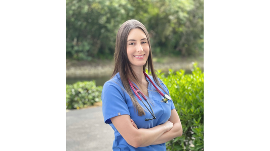 MeredithDr. Nicholle Restrepo -Veterinarian with a stethoscope, standing outdoors with arms crossed.